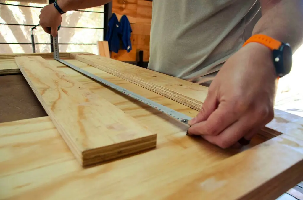 Joiner measuring a timber board in the workshop